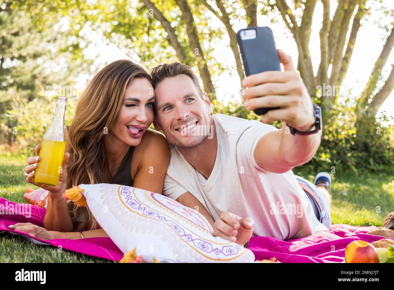 Smiling couple taking selfie in park Stock Photo