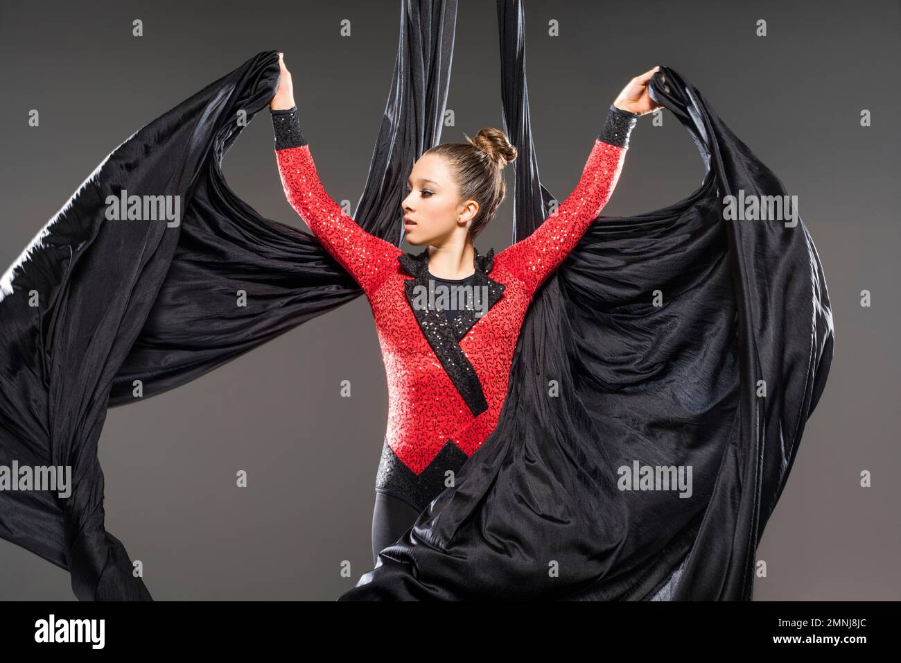 Young acrobat performing with aerial silks Stock Photo