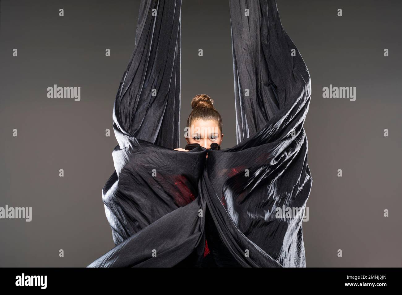 Young acrobat performing with aerial silks Stock Photo