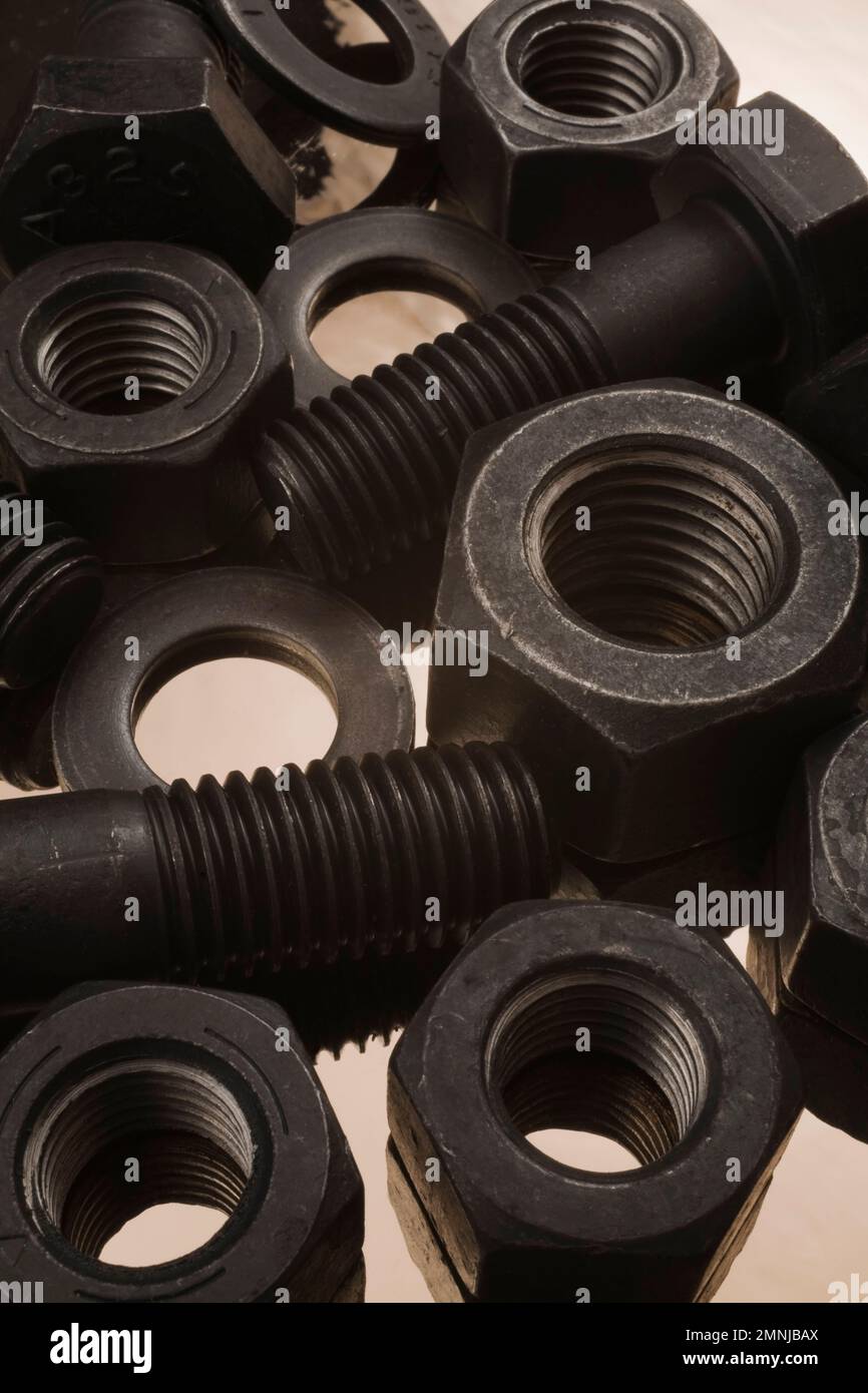 Large black steel bolts, nuts and washers on tin foil background. Stock Photo