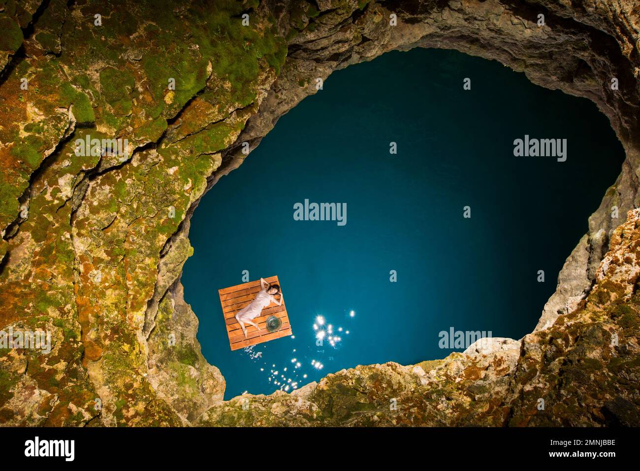 Aerial view of woman lying on wooden raft Stock Photo