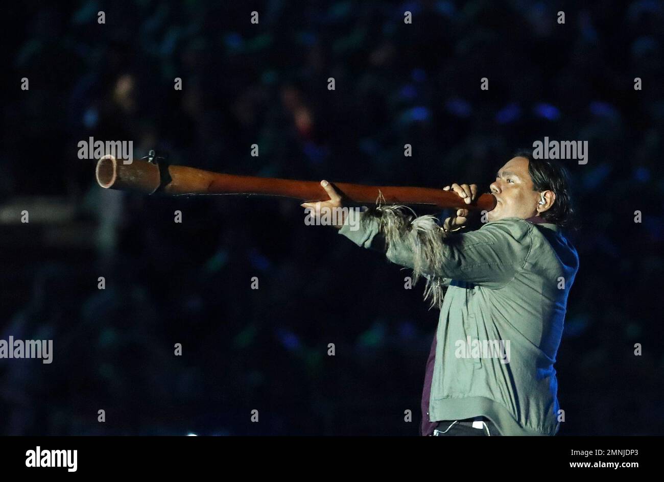A man plays the didgeridoo, a traditional Aboriginal instrument, during