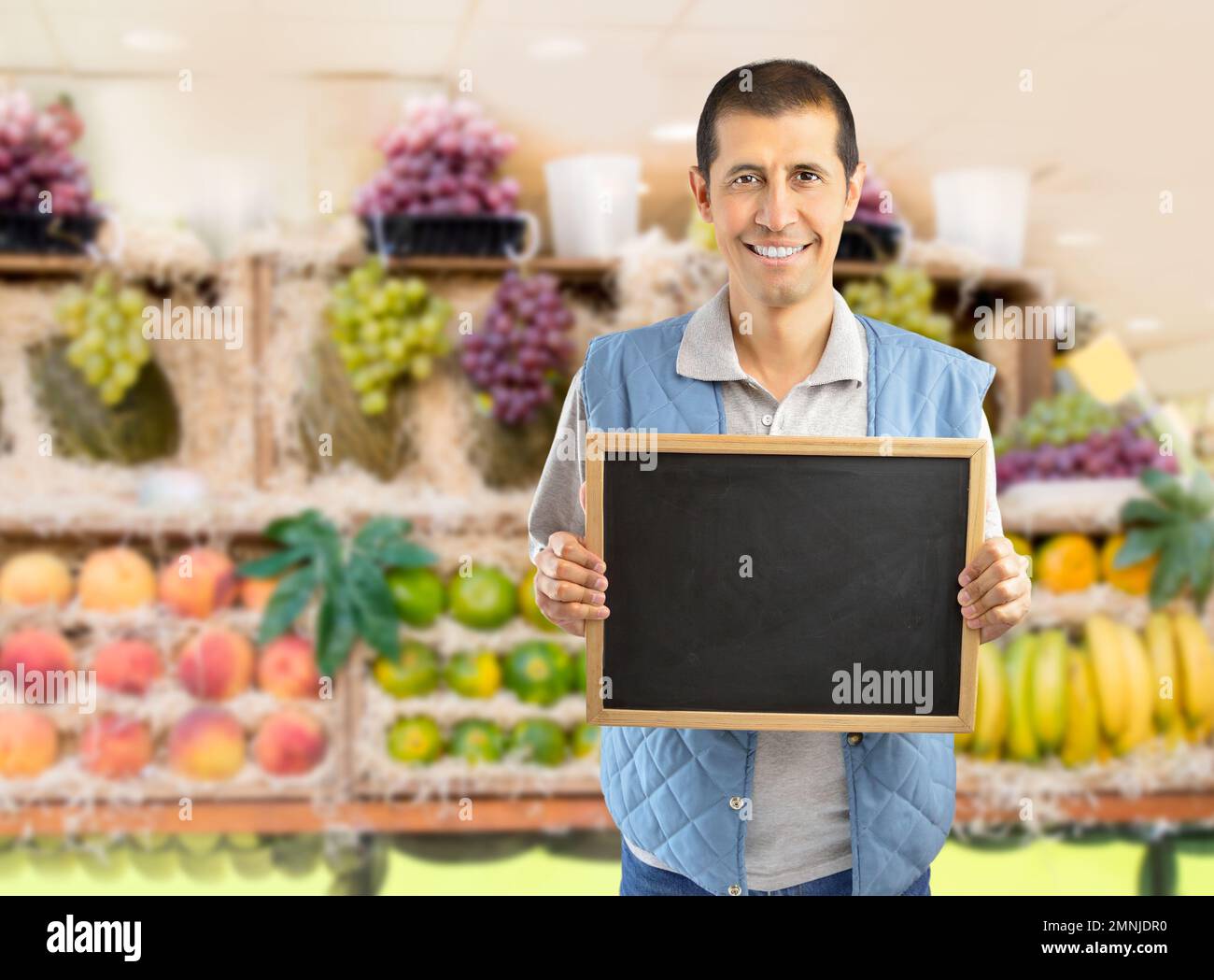 farmer holding an empty chalkboard at the fruits store Stock Photo