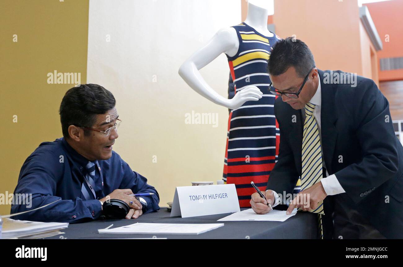 In this Oct. 3, 2017, photo, job seeker Israel Tirado, right, fills out