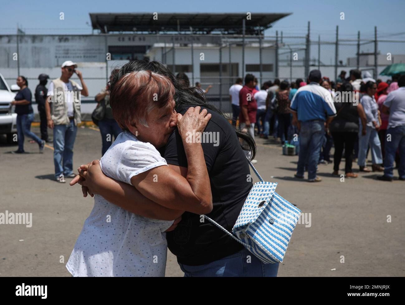 Inmates' relatives embrace outside La Toma prison in Amatlan de los