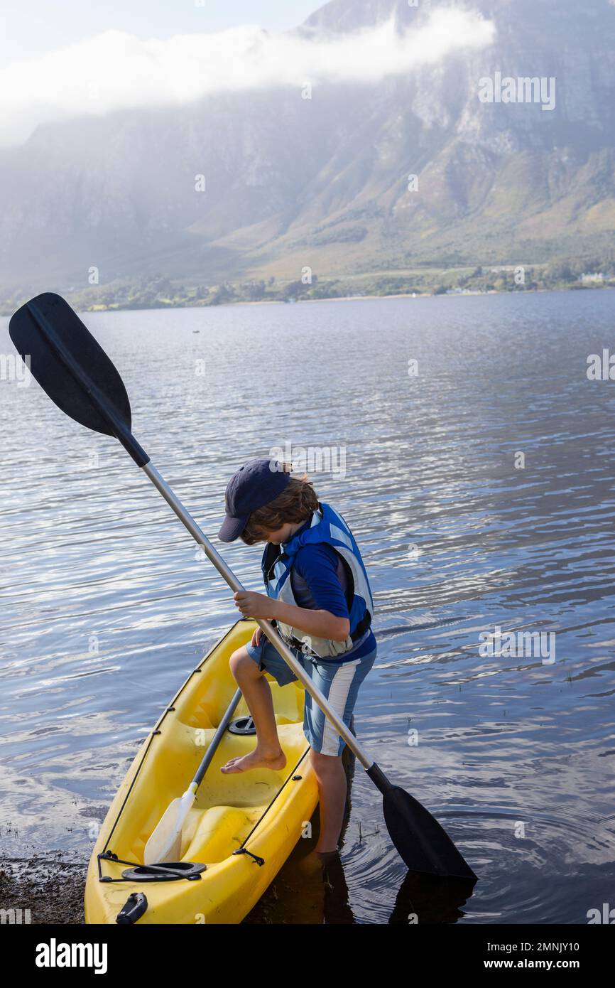 South Africa, Stanford, Boy (10-11) entering kayak in lagoon Stock Photo