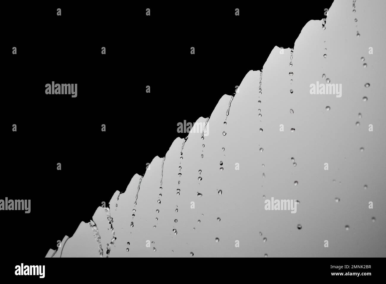 Close-up drops of rain fall from the roof, in the rainy season Stock Photo