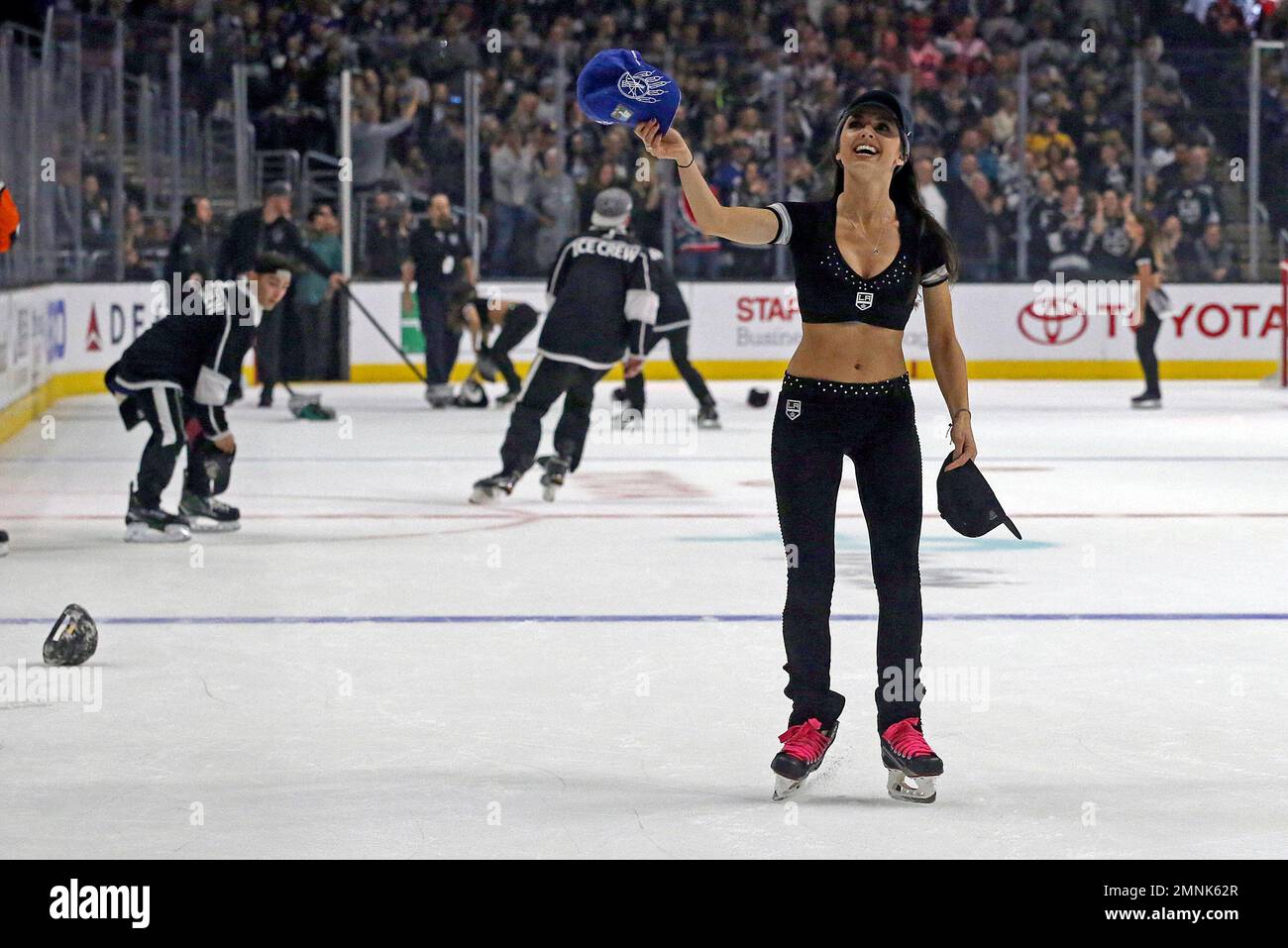 A member of the Los Angeles Kings ice crew helps collect hats thrown on