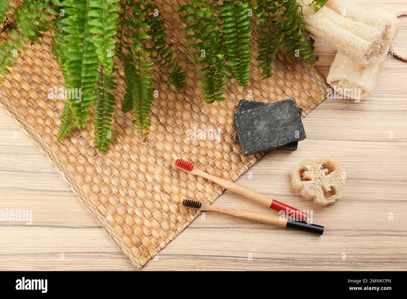 Flat lay composition with natural bamboo toothbrushes on wooden table Stock Photo