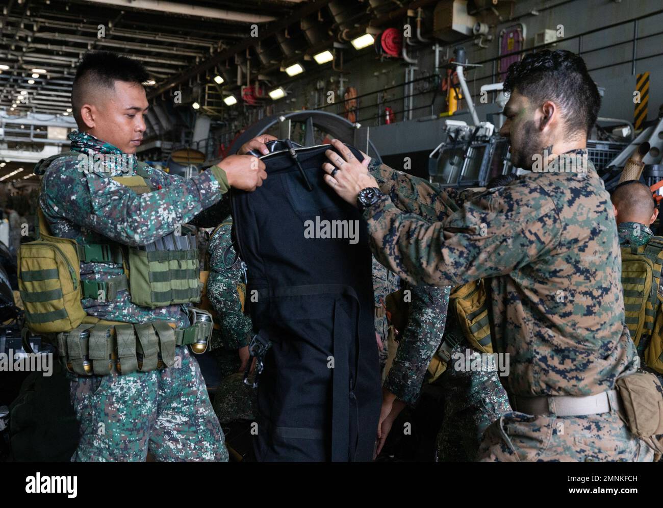 U.S. Navy Hospital Corpsman 3rd Class Jacob Fimbres, a Los Angeles, California, native, with Battalion Landing Team 2/5, 31st Marine Expeditionary Unit, and a Philippine Marine zip up a gun bag aboard the Amphibious Transport Dock USS New Orleans (LPD 18) for KAMANDAG 6, in the Philippine Sea, Oct. 3, 2022. The two forces participated in a bilateral amphibious assault focused on increasing interoperability and shared understanding of tactics. KAMANDAG is an annual, bilateral exercise between the Armed Forces of the Philippines and U.S. military designed to strengthen interoperability, capabili Stock Photo