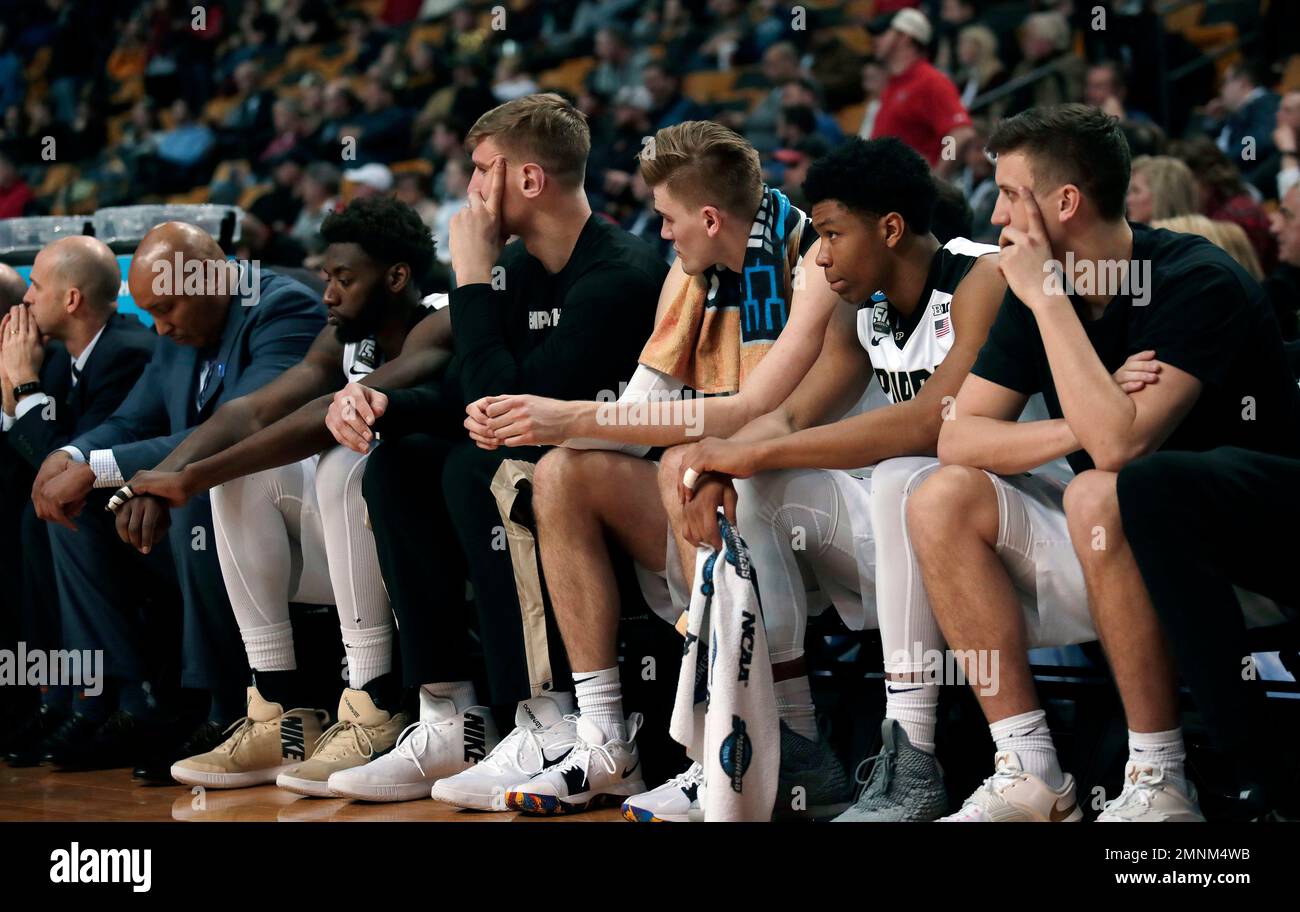 Purdue players sit on the bench near the end of an NCAA men's college