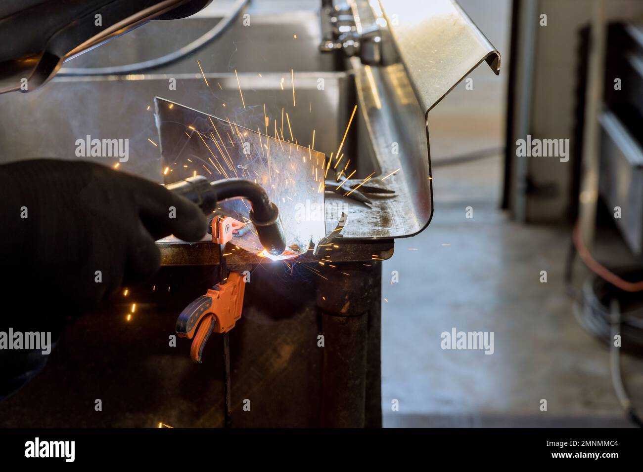 Worker working welding metal with sparkle using welding machine semi automatic argon gas shielded welding Stock Photo