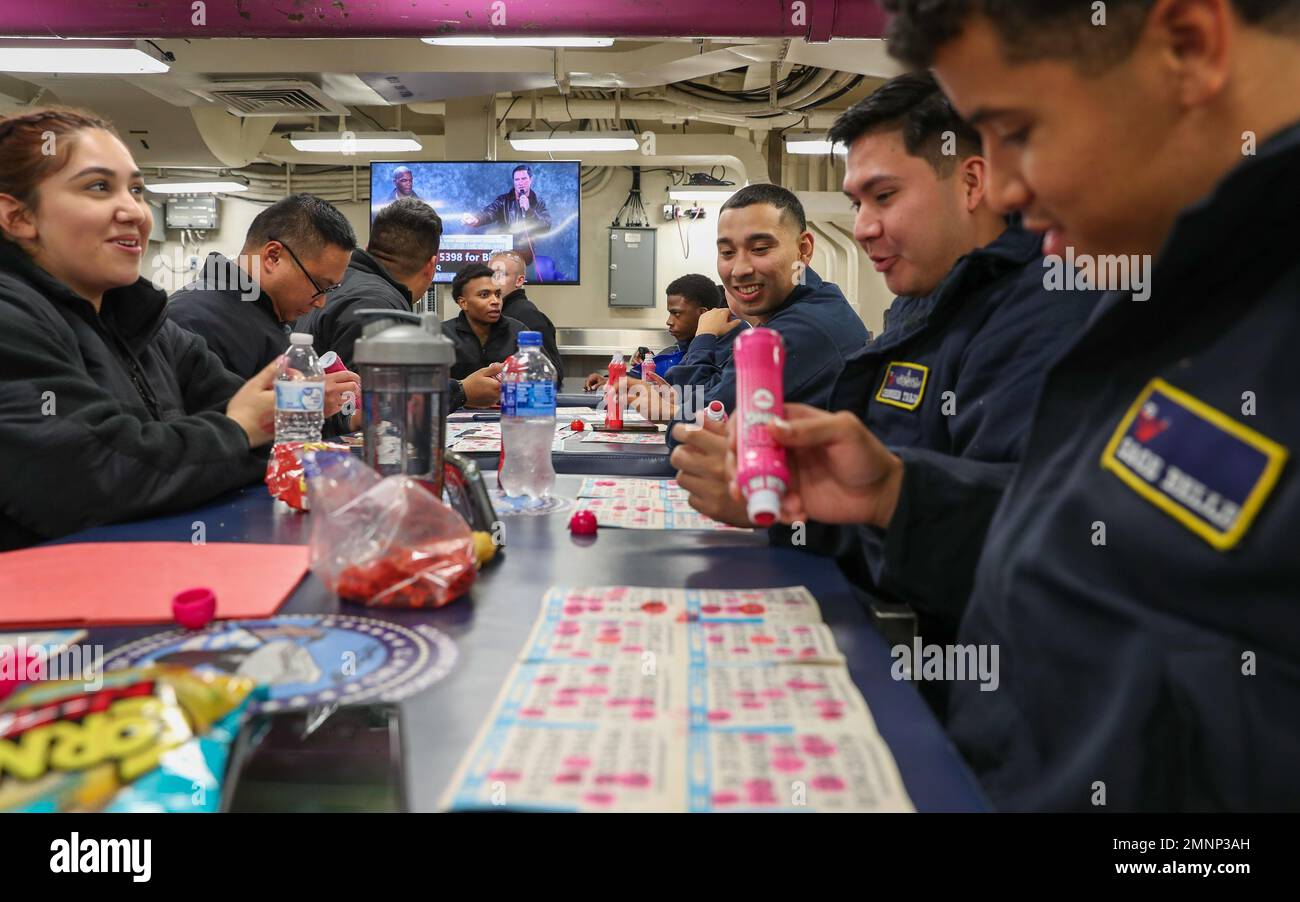 Sailors assigned to the Nimitz-class aircraft carrier USS George Washington (CVN 73) play bingo in the mess decks onboard the ship in Newport News, Virginia, Oct. 4, 2022. George Washington is conducting a simulated underway to validate shipboard habitability and operational services to ensure the ship meets the final refueling and complex overhaul (RCOH) milestones. RCOH is a multi-year project performed only once during a carrier’s 50-year service life that includes refueling the ship’s two nuclear reactors, as well as significant repairs, upgrades and modernization. Stock Photo