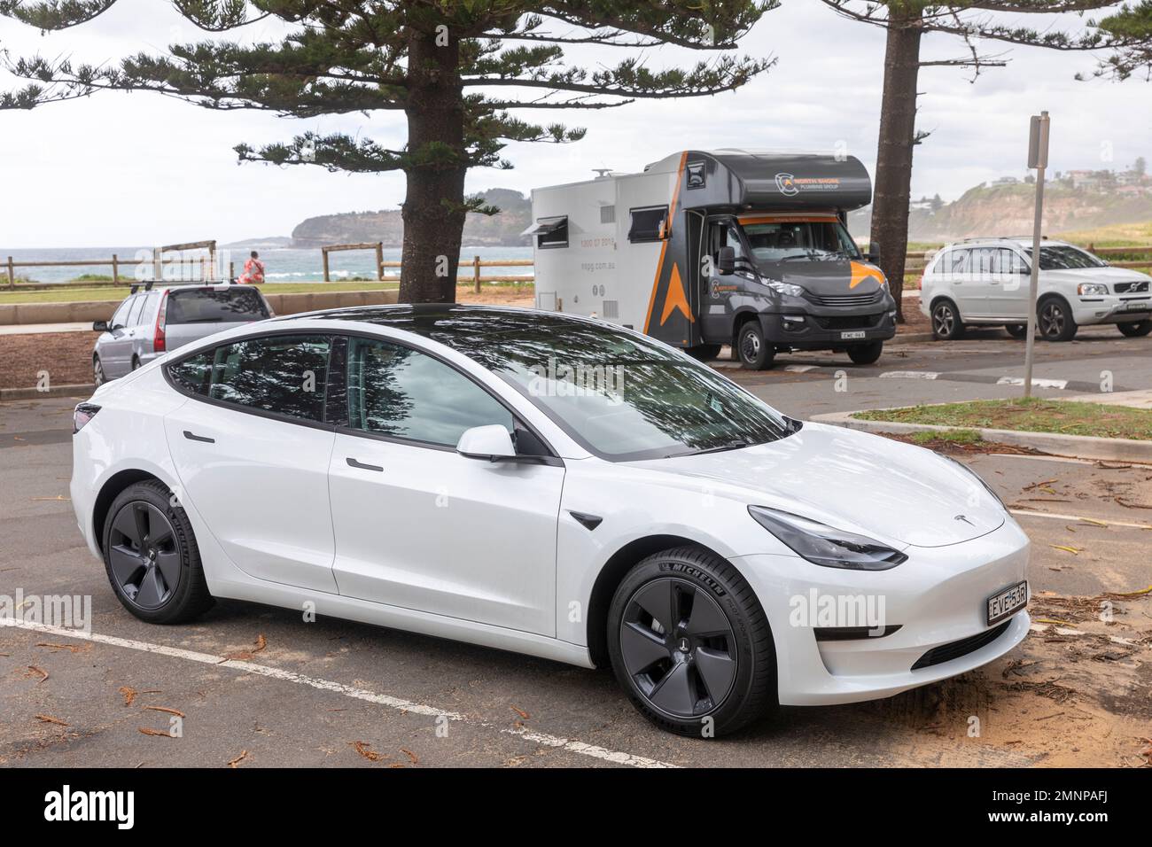 2022 Tesla Model 3 Electric vehicle  car in white parked at a Sydney beach carpark,NSW,Australia Stock Photo
