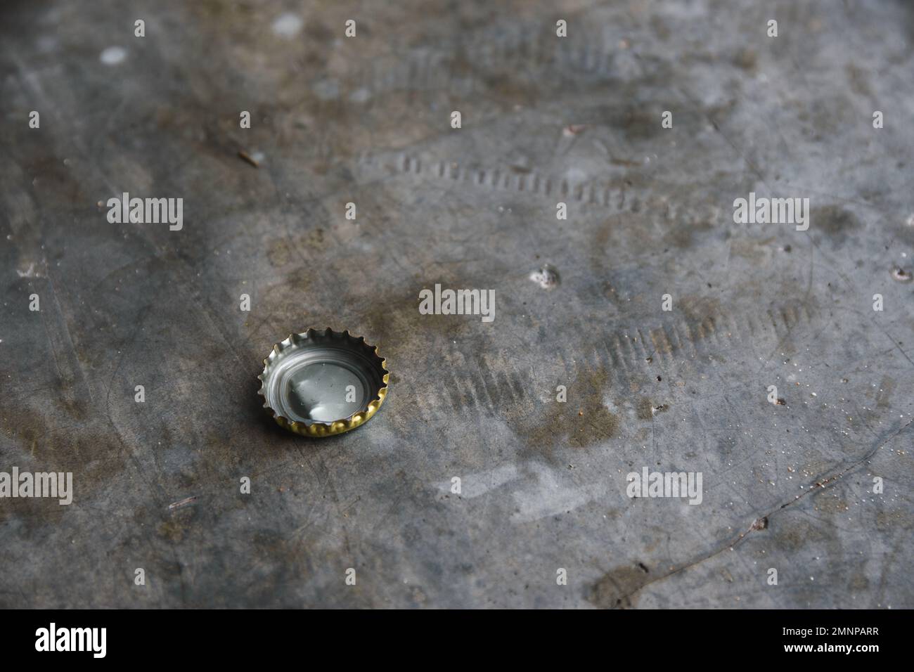 Bottle cap on a grey stone surface with copy space Stock Photo