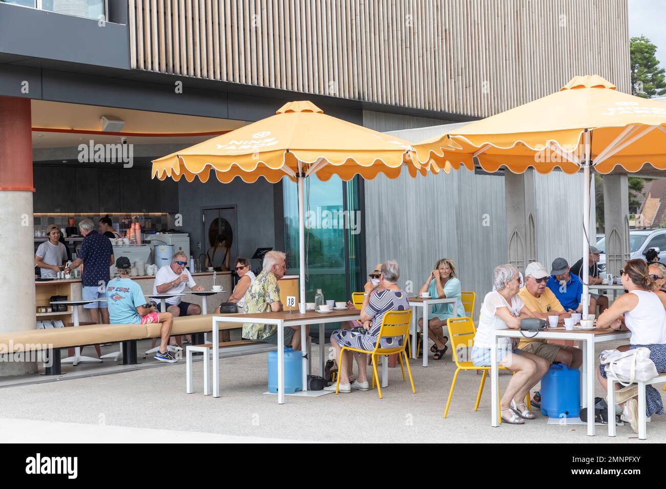 Mona Vale Surf Club building and adjacent coffee shop cafe with retired and elderly people enjoying drinks and food,Sydney,NSW,Australia Stock Photo
