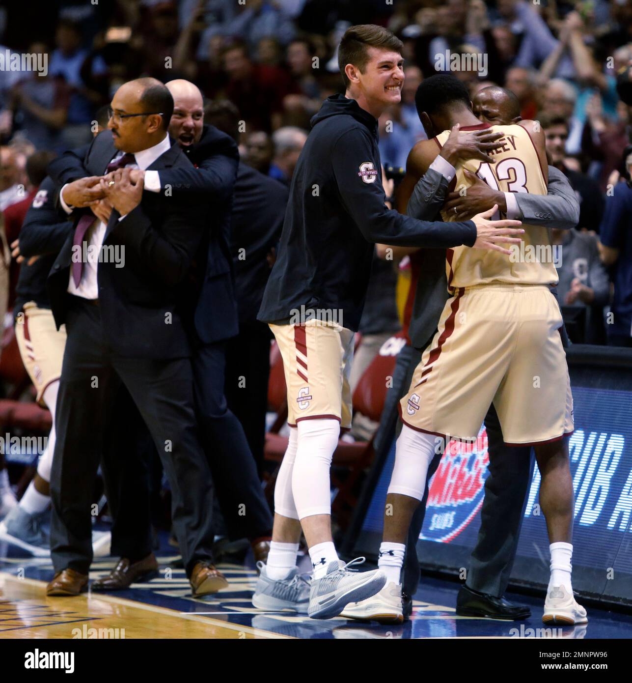 College of Charleston's head coach Earl Grant, at right, hugs player