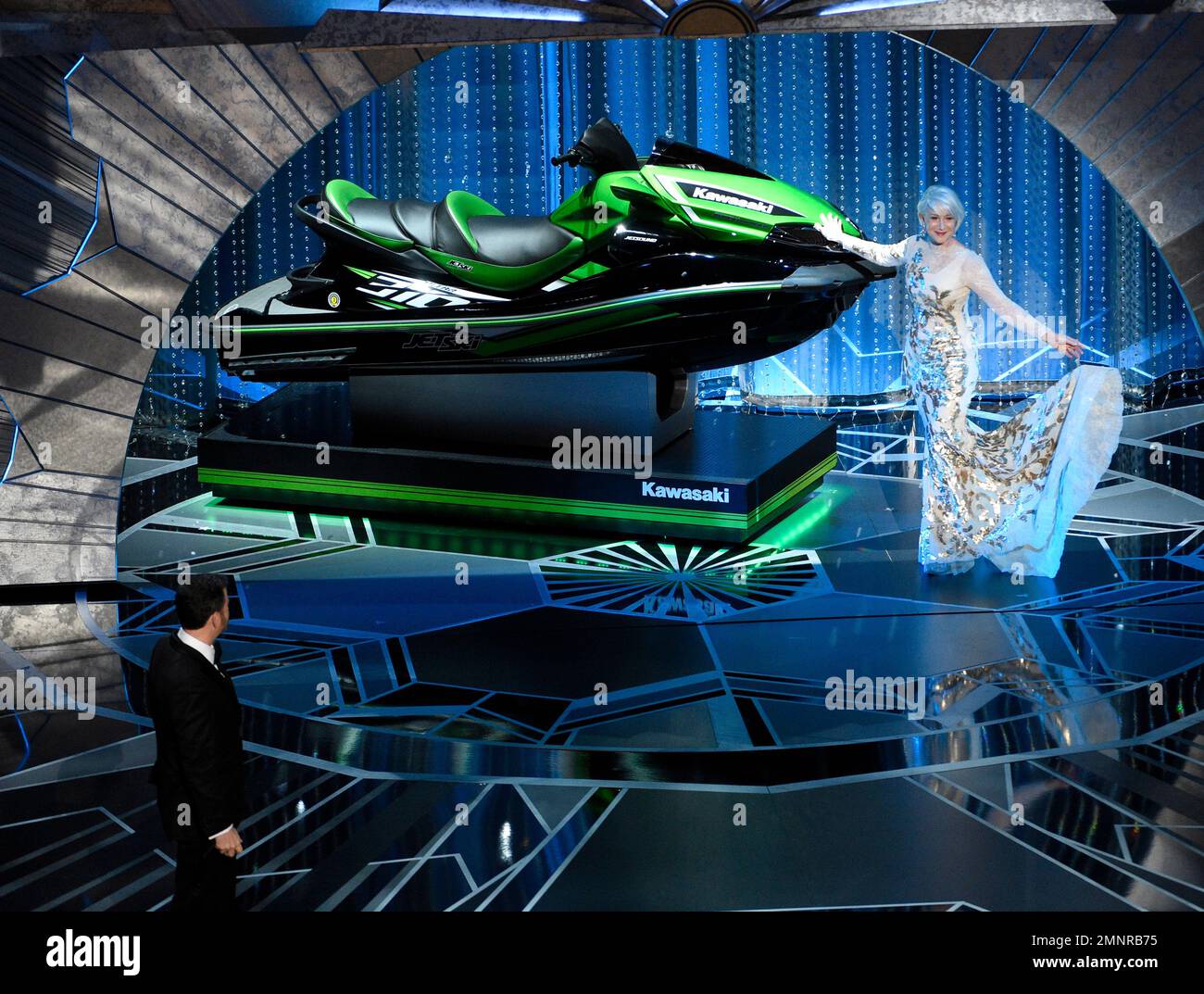 Helen Mirren displays a jet ski as host Jimmy Kimmel looks on, left, at