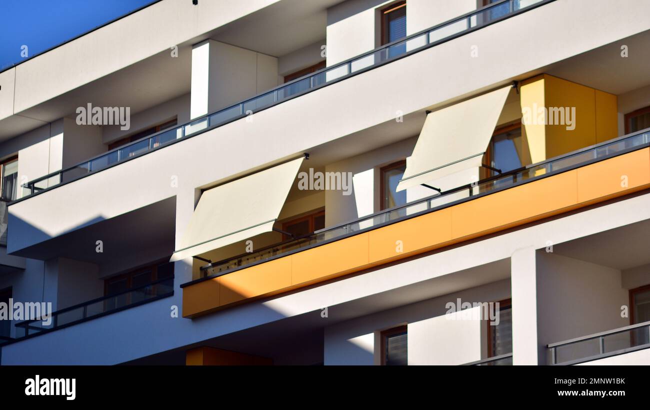 Modern architecture building facade with awnings. Balcony with awning opened, covered by sun