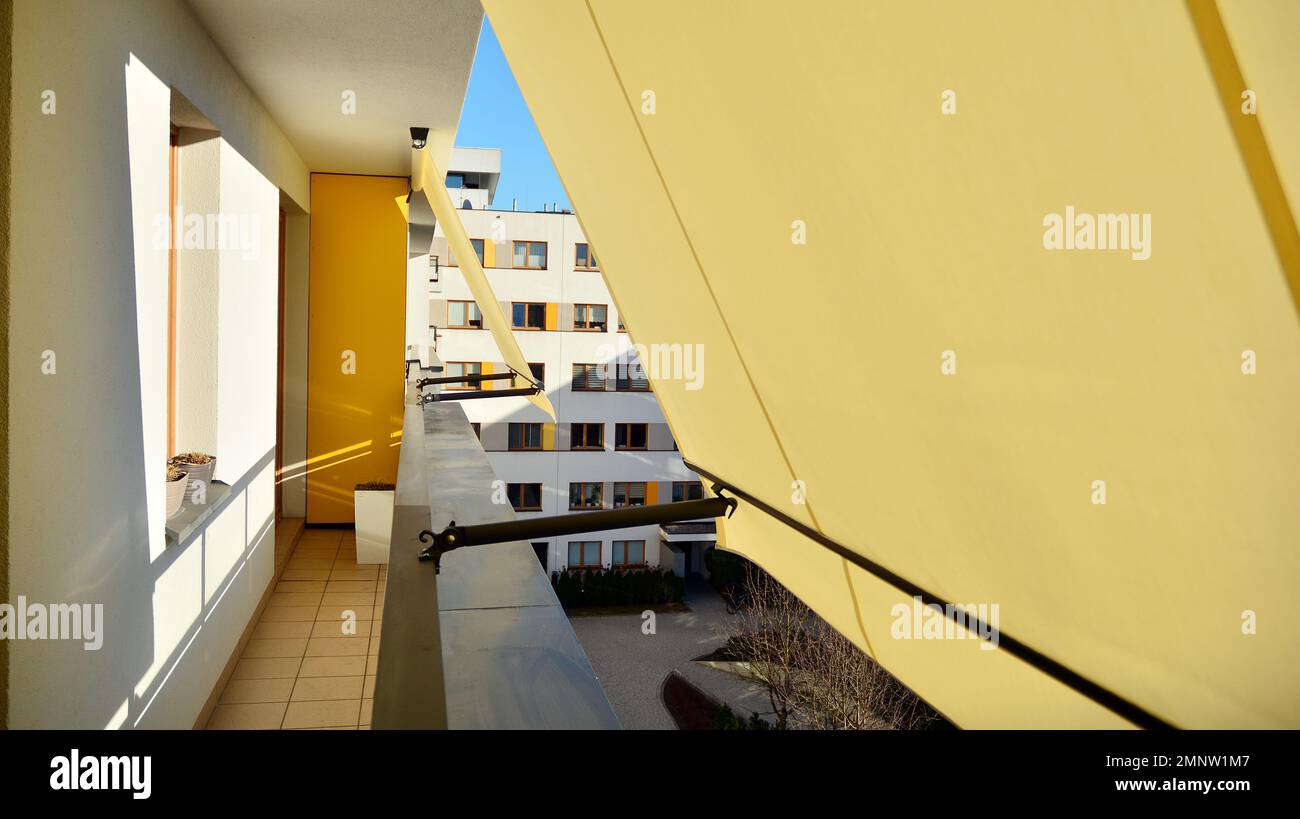 Modern architecture building facade with awnings. Balcony with awning opened, covered by sun