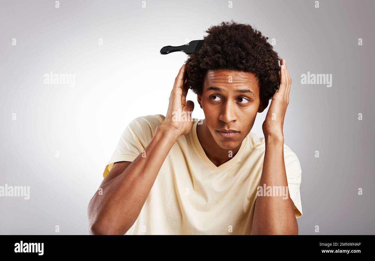 Keep calm and flaunt your afro. Studio shot of a young man posing with his  afro comb in his hair Stock Photo - Alamy