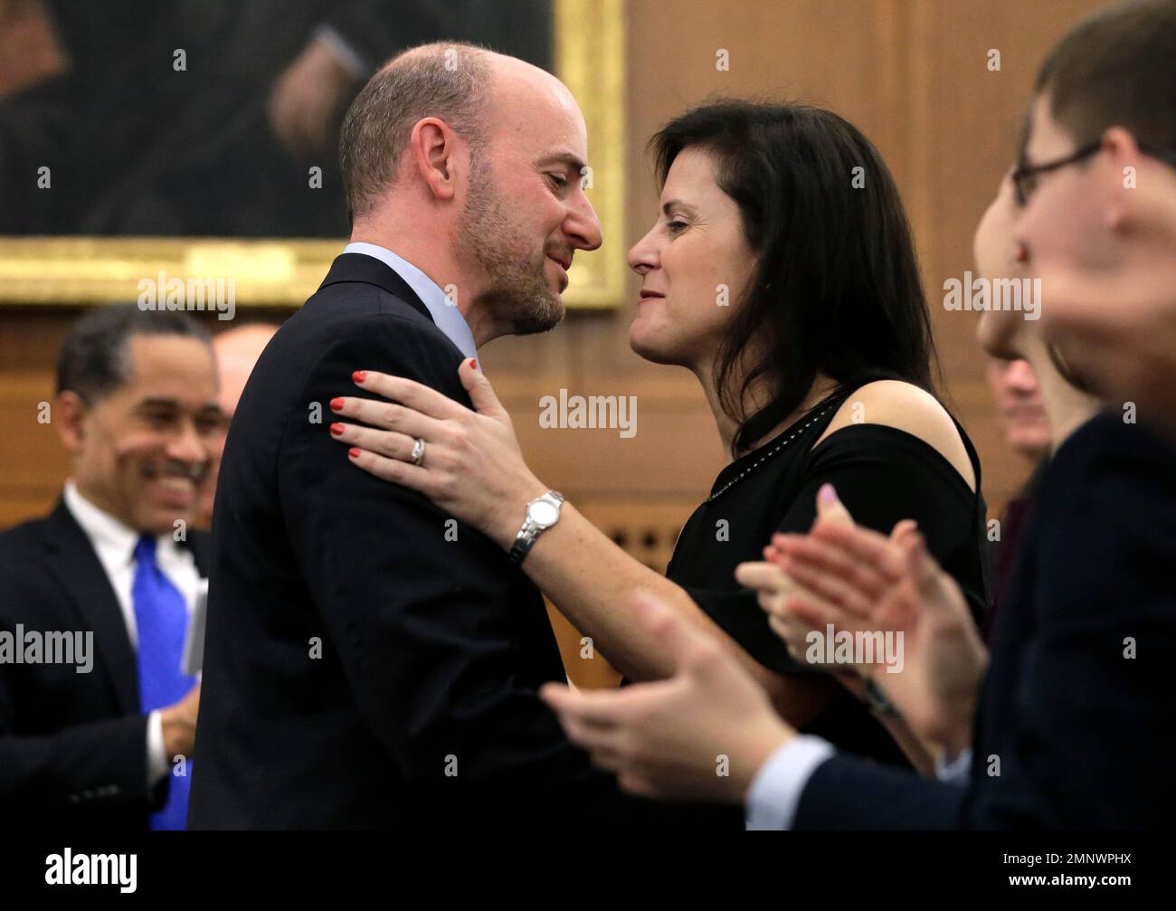 Andrew Lelling, U.S. attorney for Massachusetts, center left, embraces his wife Dana Gershengorn, center right, following installation ceremonies for Lelling as the state's chief federal law enforcement officer, Wednesday, Feb. 21, 2018, at federal court, in Boston. (AP Photo/Steven Senne) Stock Photo