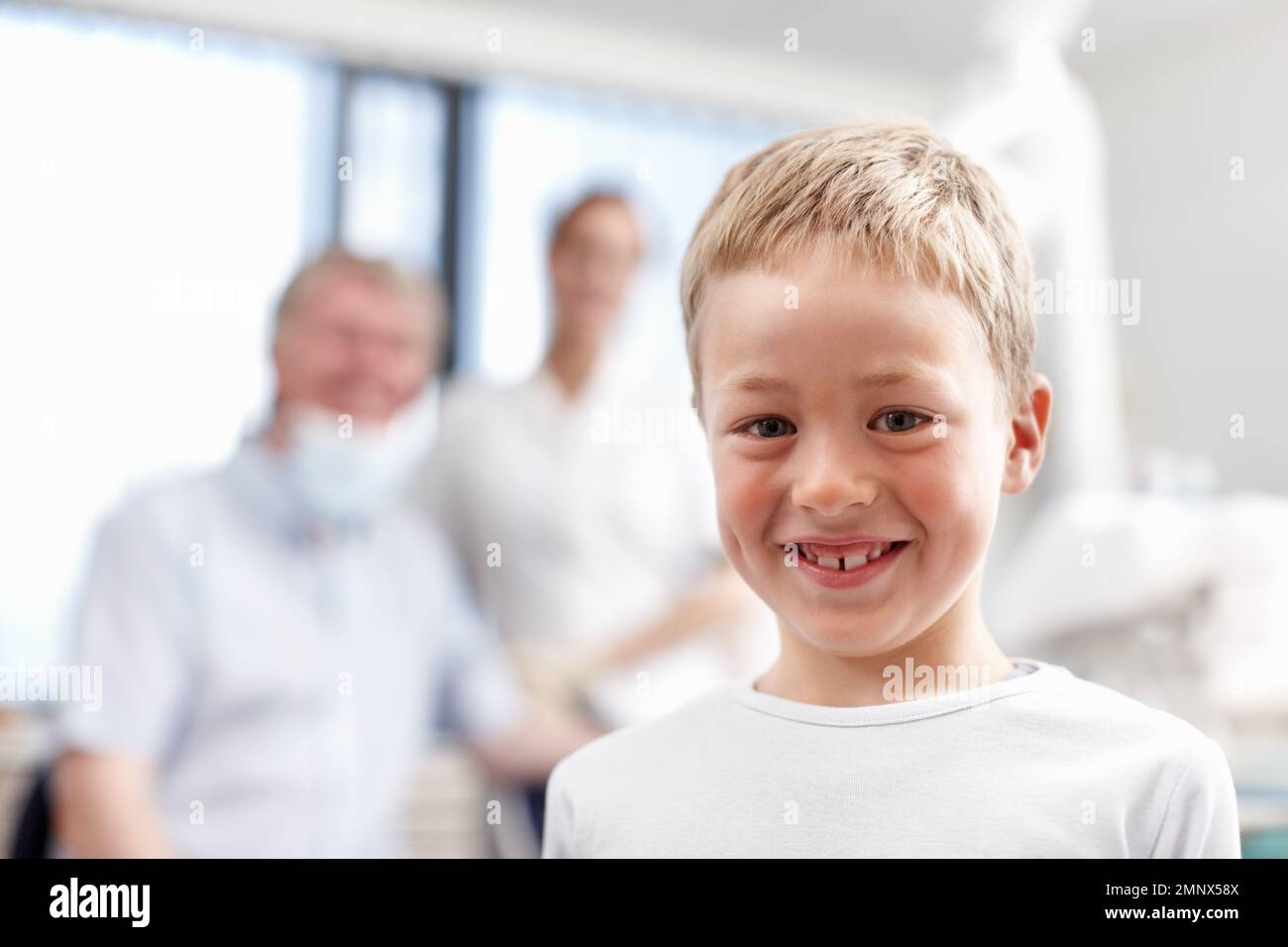 Boy with healthy teeth. Portrait of adorable young boy smiling with dentists in background. Stock Photo