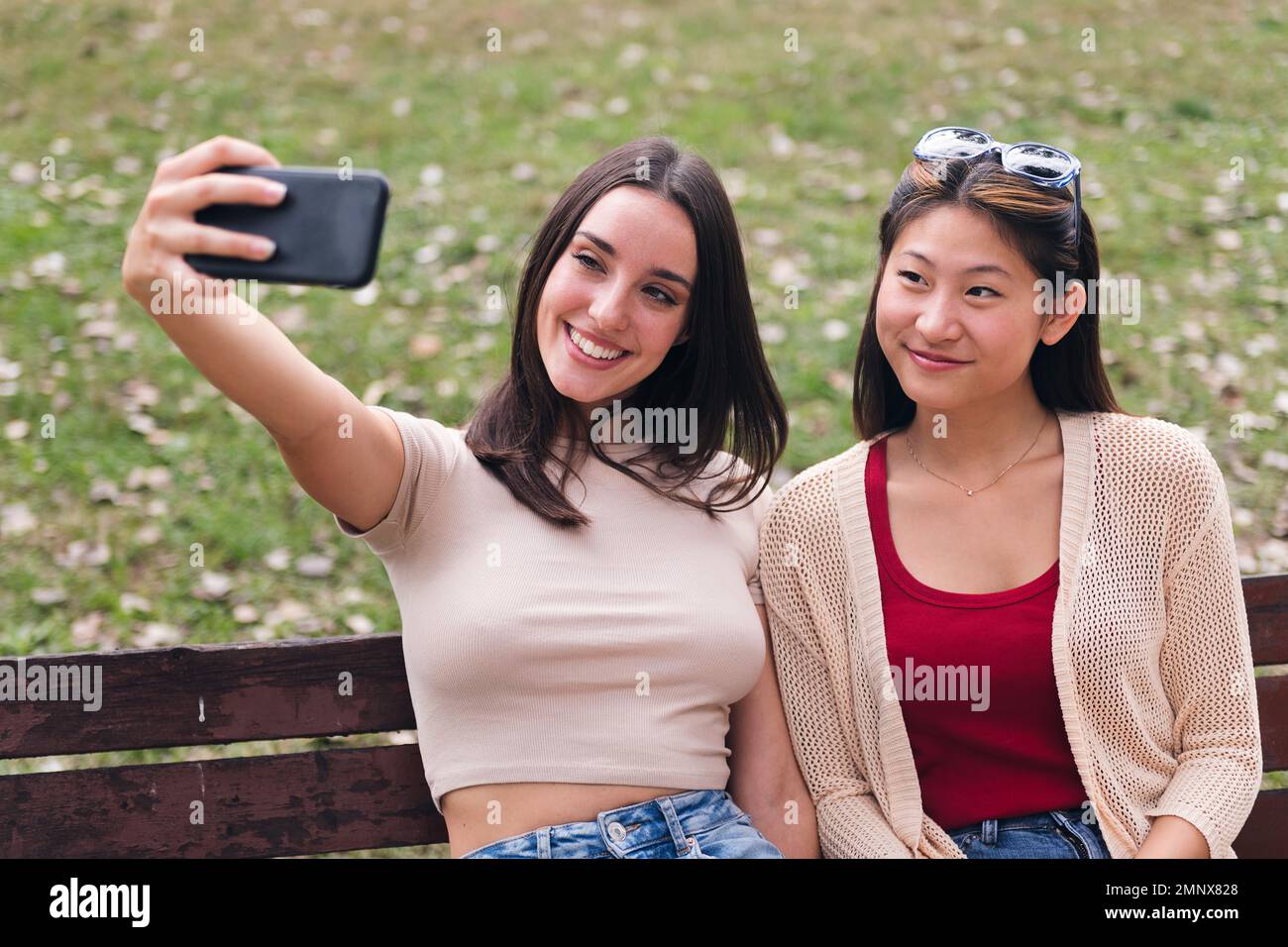 two young women smiling happy while taking a photo Stock Photo