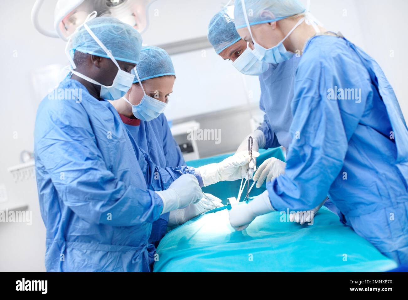 Experts in Anatomy. Surgical doctors operating on a patient in a hospital. Stock Photo