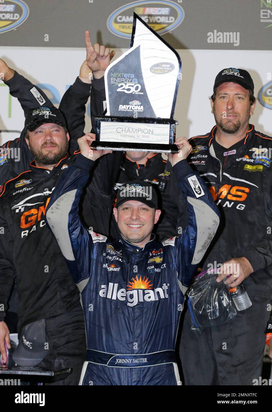 Johnny Sauter raises the trophy in Victory Lane after winning the ...