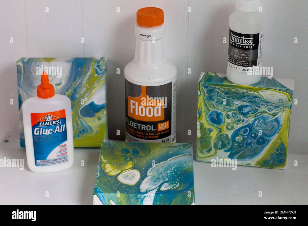 This Feb. 11, 2018 photo shows three different mediums Elmer's glue, Floetrol  paint additive and Liquitex pouring medium and the resulting art on canvas  made by mixing them together in Hopkinton, N.H.