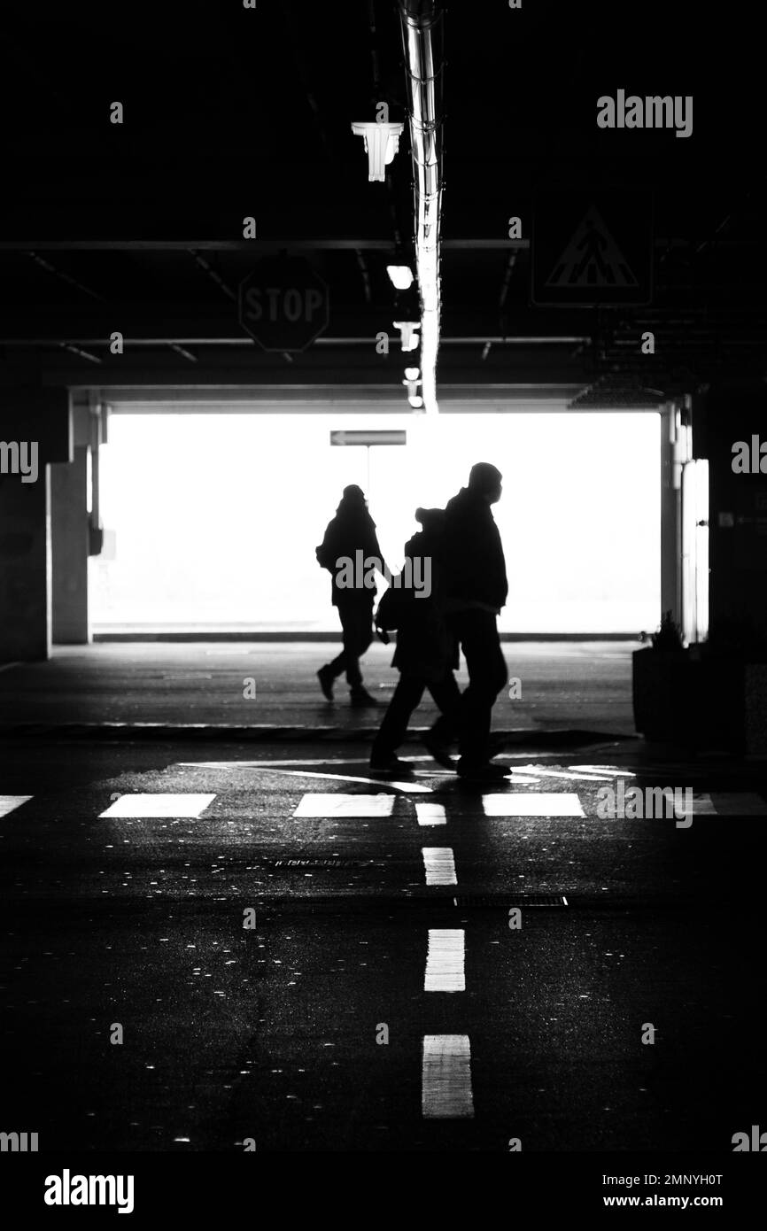 People stroll inside an underground car park Stock Photo