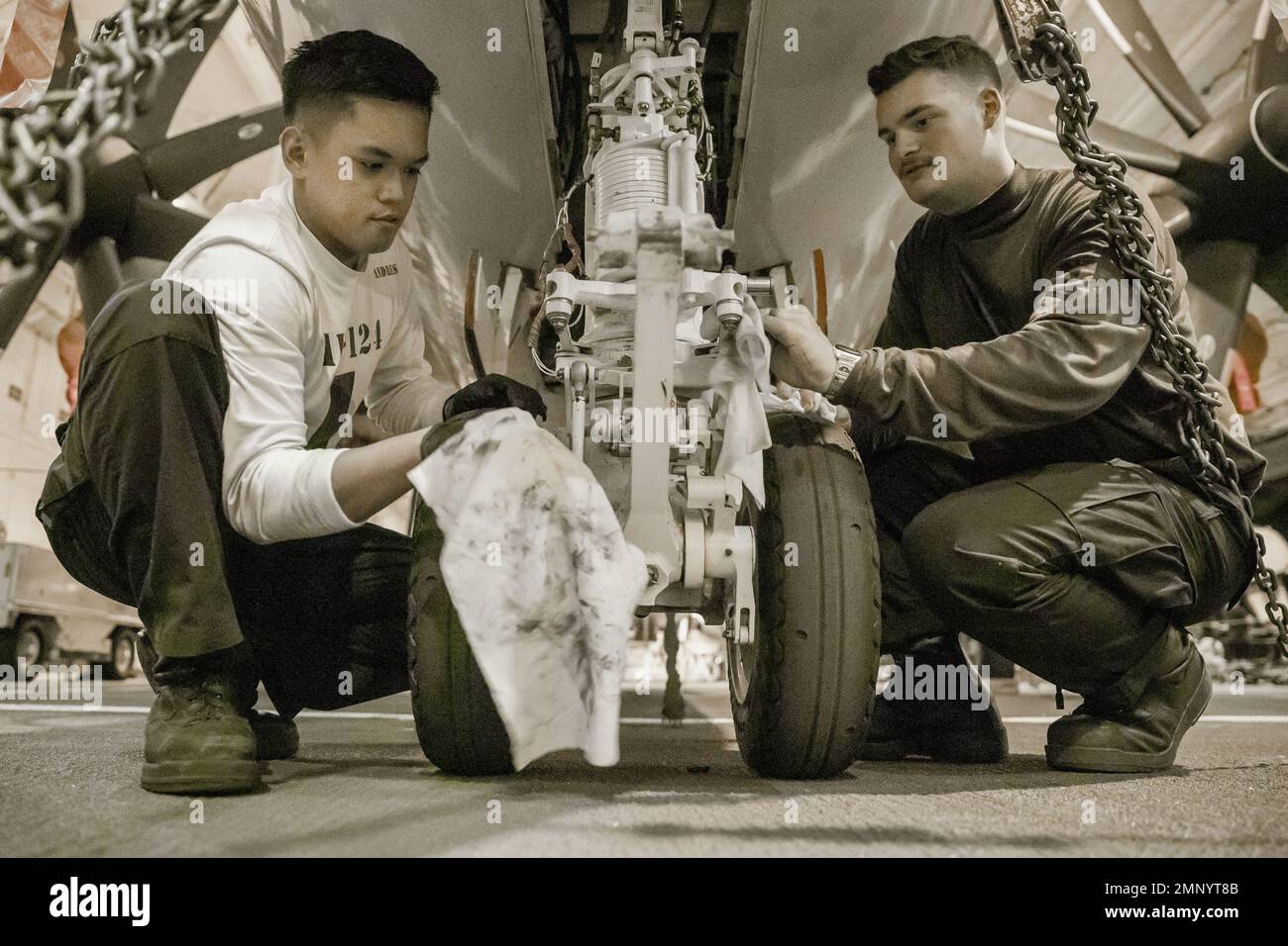 Aviation Structural Mechanic Airman John Andres, left, from South Cotabato, Philippines, and Aviation Structural Mechanic 3rd Class Aiden Burgess, from Charleston, South Carolina, both assigned to the 'Bear Aces' of Airborne Command and Control Squadron (VAW) 124, conduct routine maintenance on an E2-D Hawkeye in the hangar bay of the first-in-class aircraft carrier USS Gerald R. Ford (CVN 78), Oct. 7, 2022.  The Gerald R. Ford Carrier Strike Group (GRFCSG) is deployed in the Atlantic Ocean, conducting training and operations alongside NATO Allies and partners to enhance integration for future Stock Photo