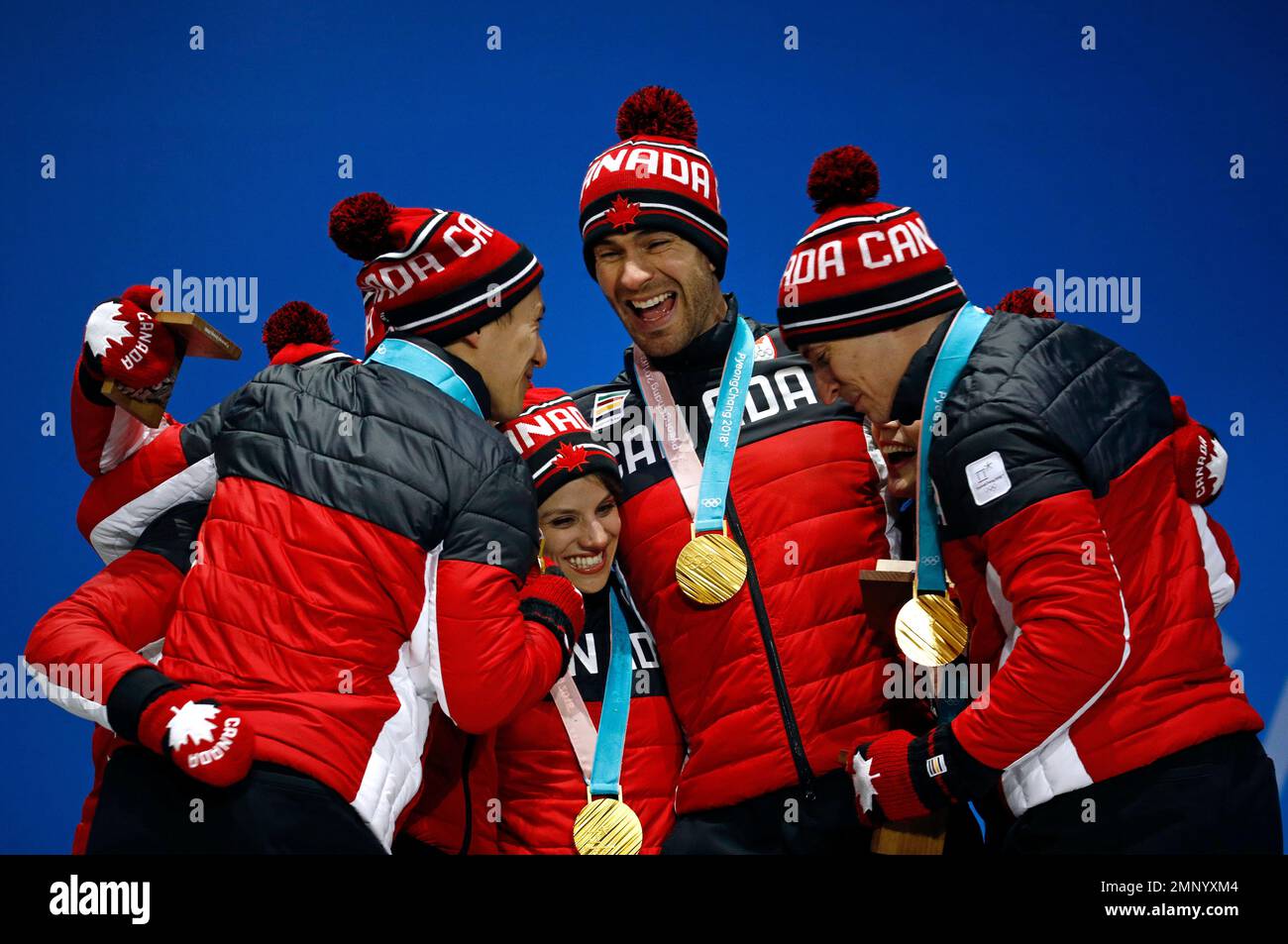 Team figure skating gold medalists from Canada celebrate during their