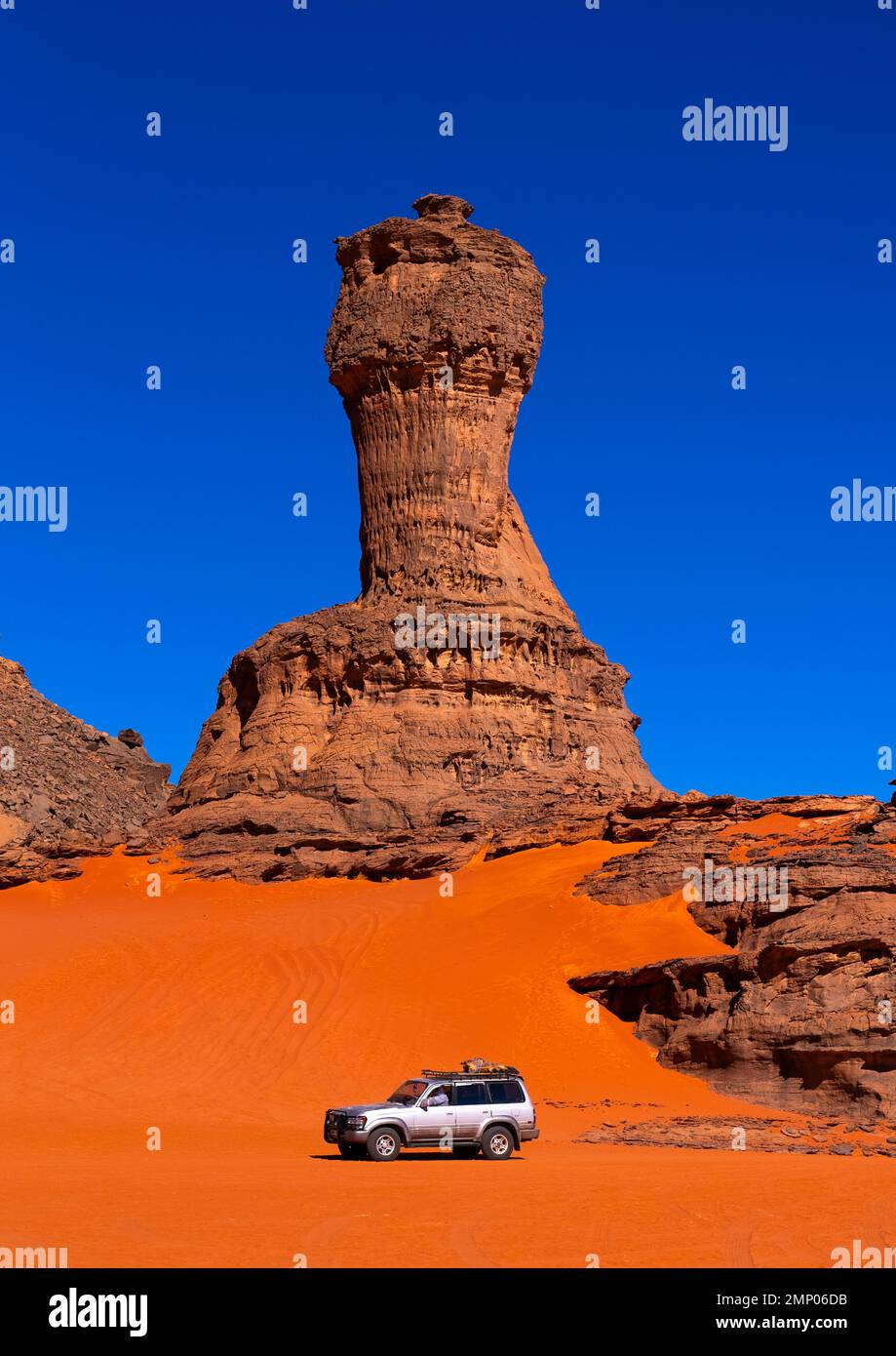 Car in front of World Cup Rock formation in Sahara desert, Tassili N'Ajjer National Park, Tadrart Rouge, Algeria Stock Photo