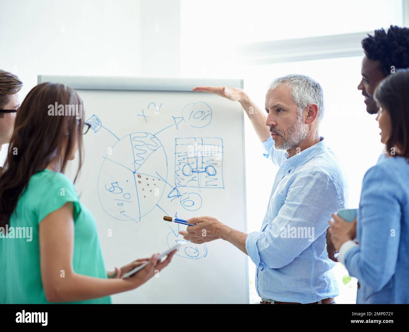Getting everyones input. a mature businessman meeting with his creative team. Stock Photo