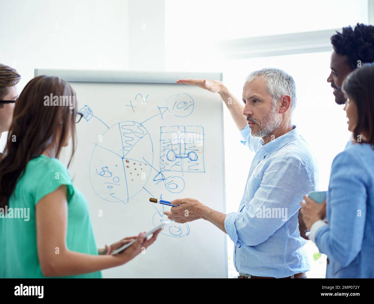 Getting everyones input. a mature businessman meeting with his creative ...