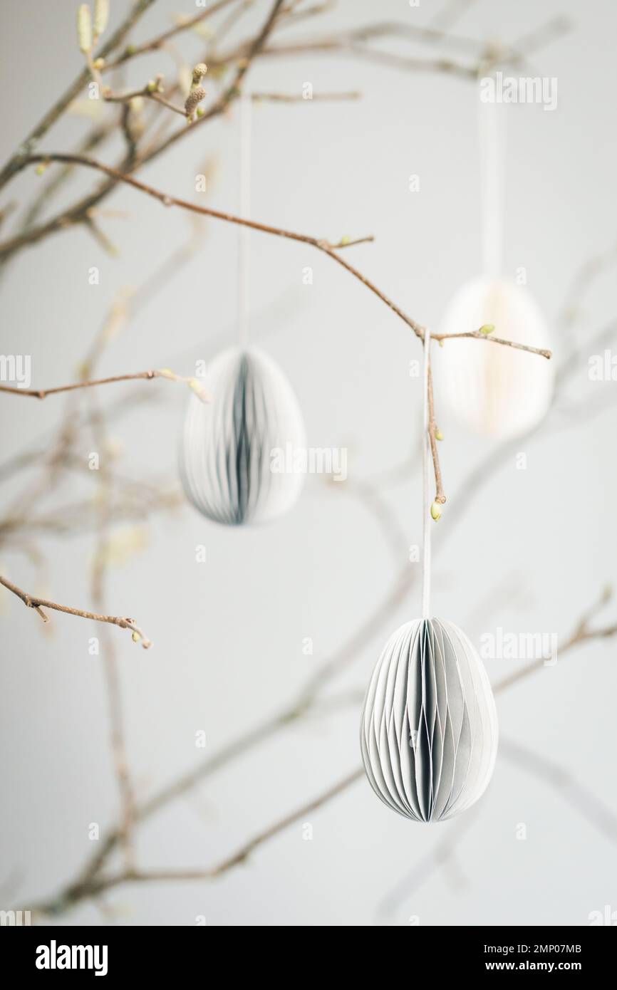 Easter paper eggs hanging on branches. Scandinavian-style Easter decorations. Stock Photo