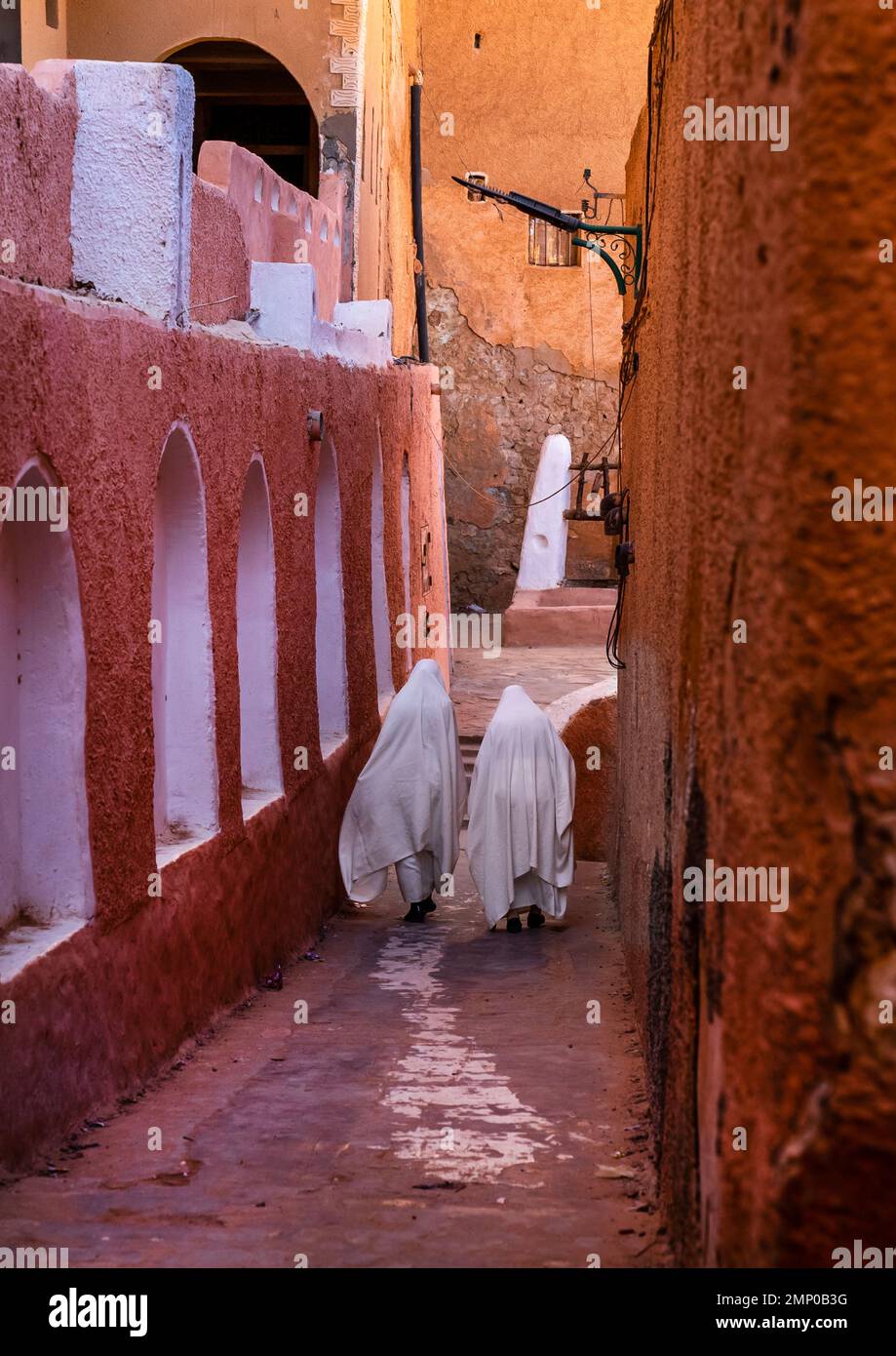 Mozabite women in white haïk in the streets of Ksar El Atteuf, North Africa, Ghardaia, Algeria Stock Photo