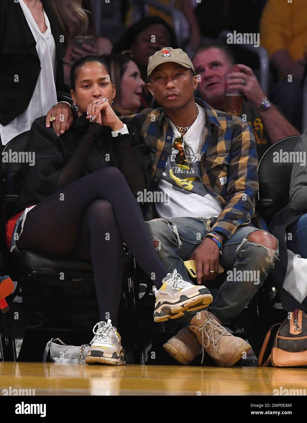Rapper Pharrell Williams watches with his wife Helen Lasichanh during the  first half of an NBA basketball game between the Los Angeles Lakers and the  Oklahoma City Thunder, Thursday, Feb. 8, 2018,