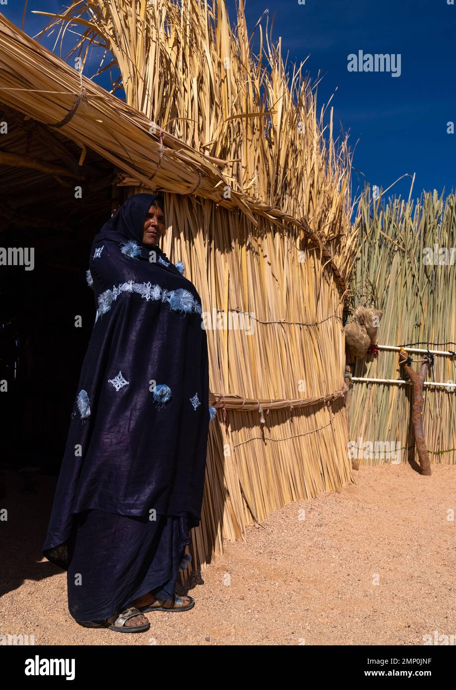 Tuareg woman standing in front of her reed house, North Africa, Tamanrasset, Algeria Stock Photo