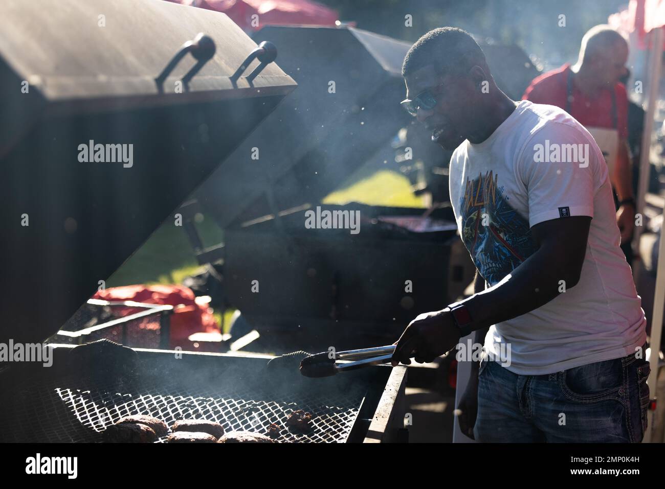 U.S. Marine Corps Sgt. Michael Robinson, assistant operations chief, Headquarters and Headquarters Squadron, Marine Corps Air Station (MCAS) Beaufort, grills burgers during the Tri-Command BBQ Bash competition at MCAS Beaufort, Oct. 7, 2022. Fire Fest hosted the competition for Marines to compete for personal prizes, unit funds and to improve camaraderie between the different commands. Stock Photo