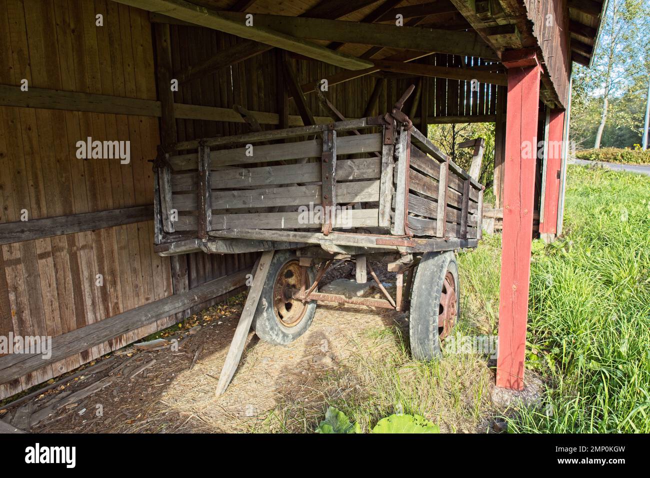 Old worn wooden wagon with rubber tyres on a farm. Stock Photo