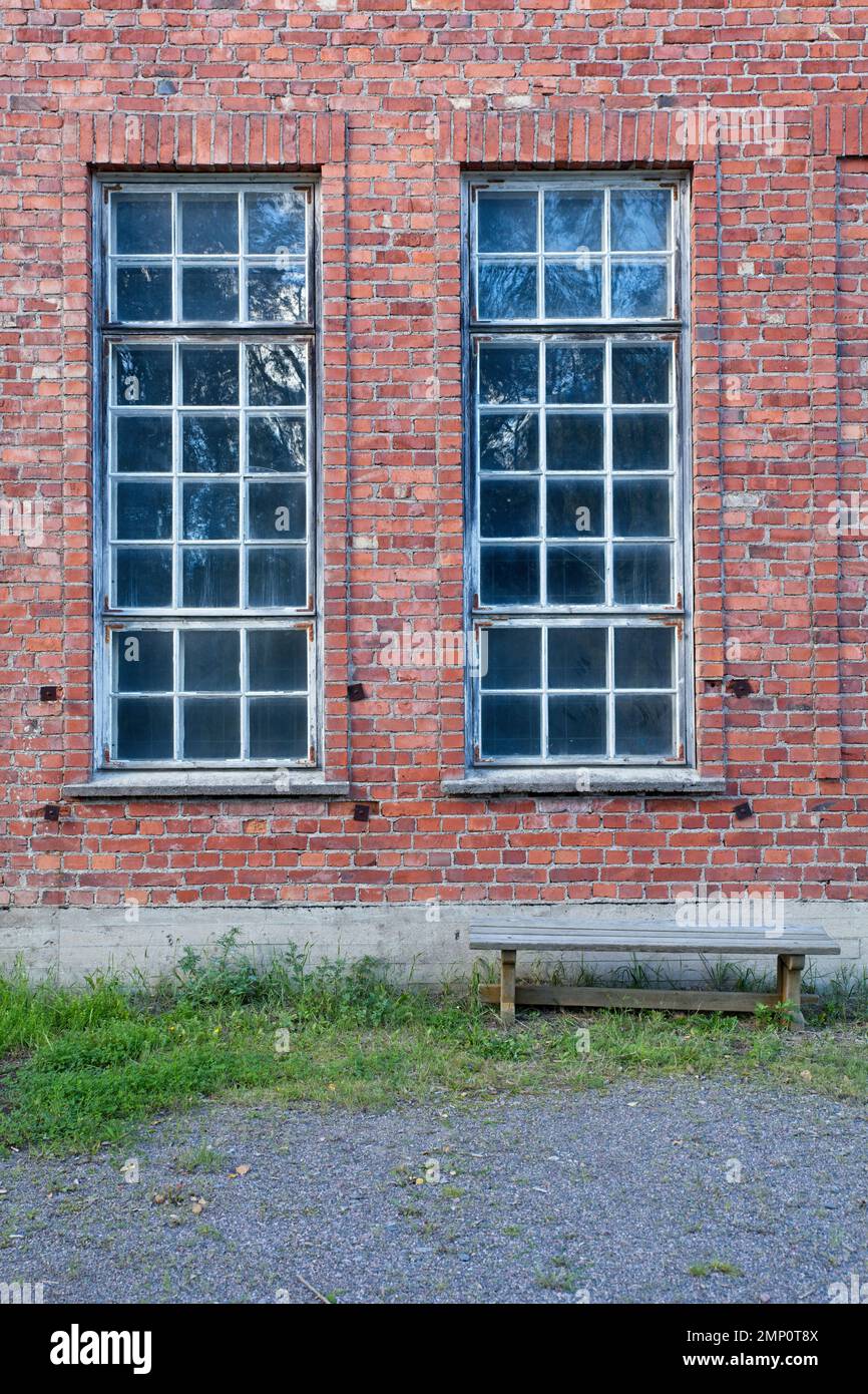 Windows on red brick wall and wood bench Stock Photo - Alamy