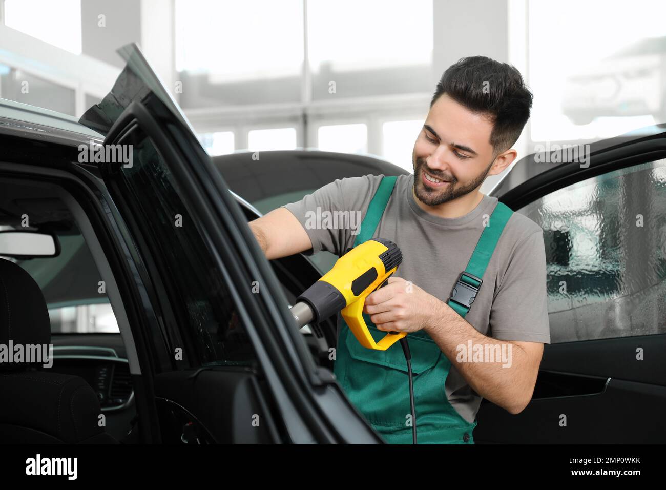 Worker tinting car window with heat gun in Stock Photo Alamy
