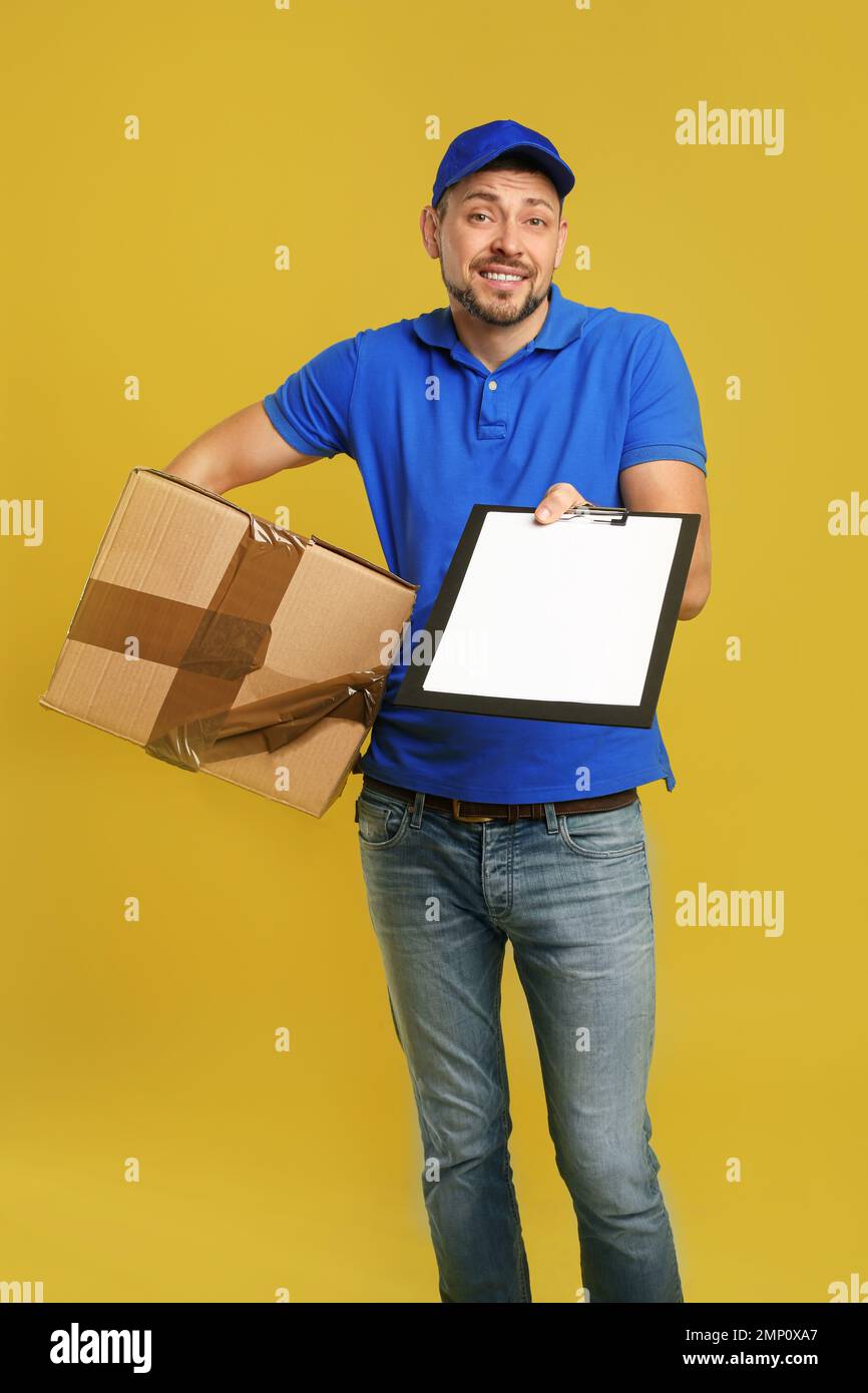 Emotional courier with damaged cardboard box and clipboard on yellow