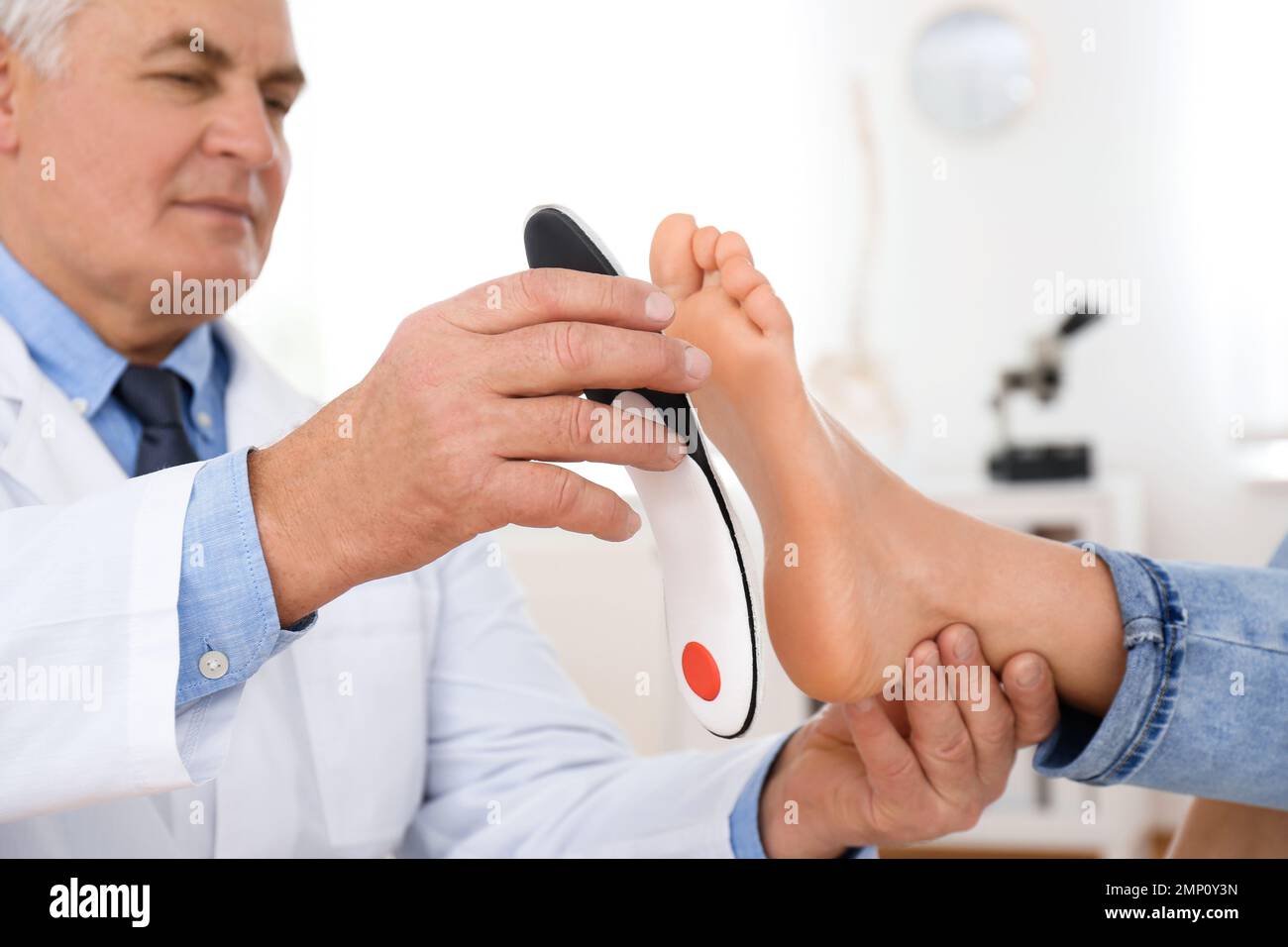 Male orthopedist fitting insole on patient's foot in clinic Stock Photo Alamy