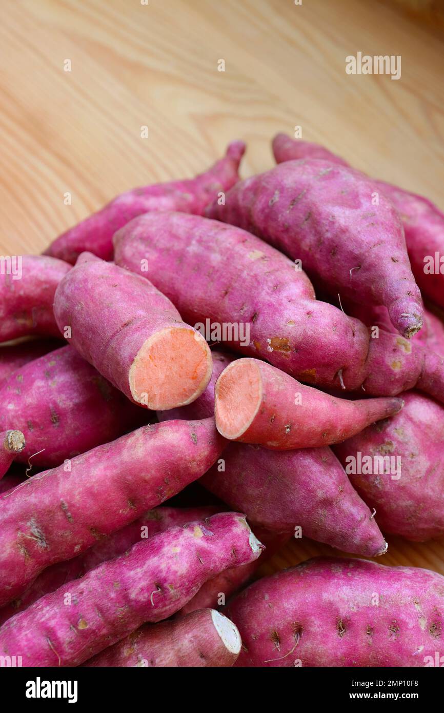 Pile of Raw Sweet Potatoes on the Wooden Table Stock Photo