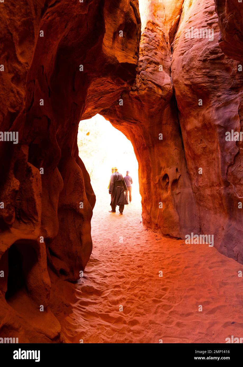 Tourists waliking in weathered sandstone passage, Tassili N'Ajjer National Park, Tadrart Rouge, Algeria Stock Photo
