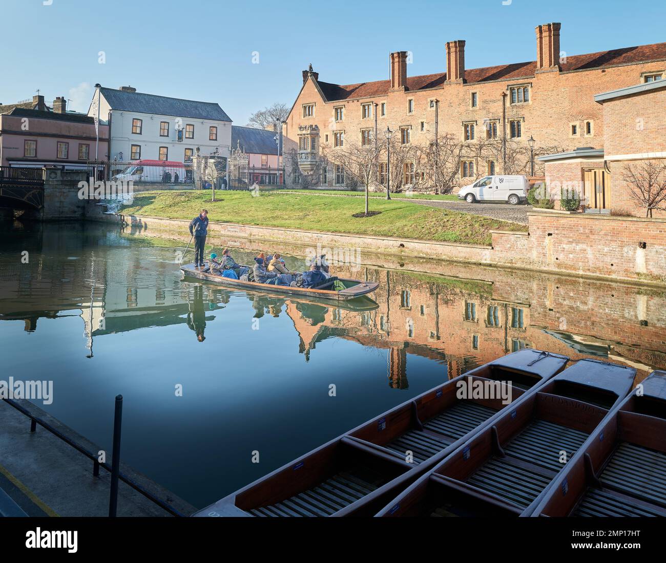 A punt load of tourists reflected in the river Cam by Magdalene college, University of Cambridge, England. Stock Photo